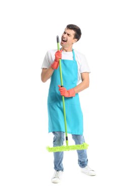Young man with floor mop singing on white background