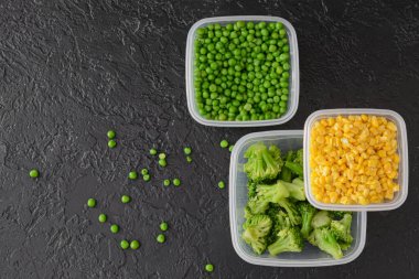 Esmer arka planda sebzeli plastik kaplar.