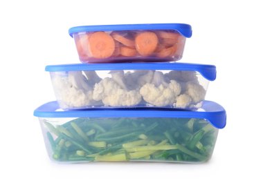 Beyaz arka planda sebzeli plastik kaplar.