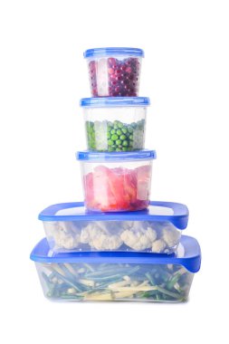 Beyaz arka planda sebze ve böğürtlen bulunan plastik kaplar.