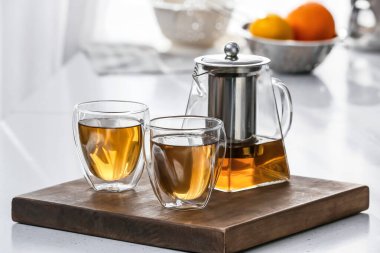 Çaydanlık ve bardaklar mutfaktaki masada sıcak çay.