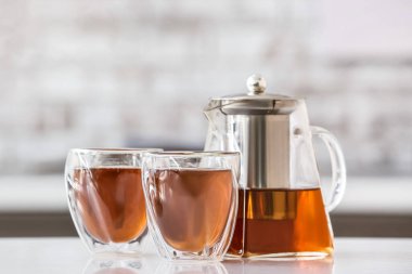 Çaydanlık ve bardaklar mutfaktaki masada sıcak çay.