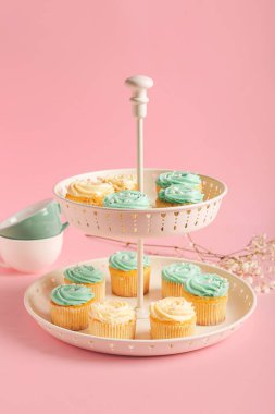 Tatlı standı, lezzetli kekler, fincanlar ve çiçeklerle renklendirilmiş arka plan