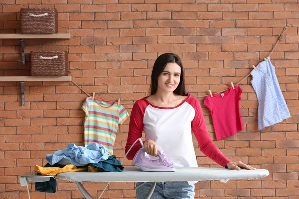 Young Woman Ironing Clothes Brick Wall — Stockfoto