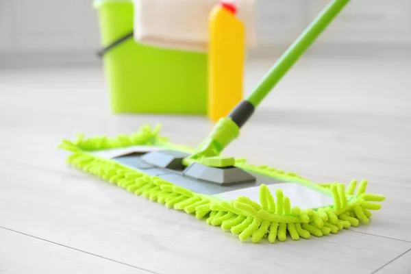 Set of cleaning supplies on floor in kitchen, closeup