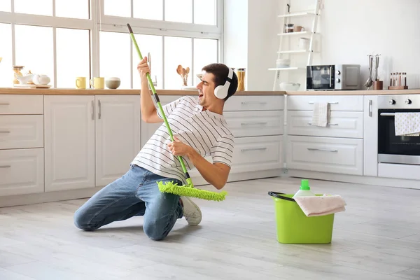 Young Man Mopping Floor While Listening Music Kitchen — Zdjęcie stockowe