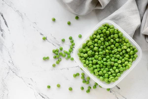 Envase Plástico Con Guisantes Verdes Sobre Fondo Claro — Foto de Stock