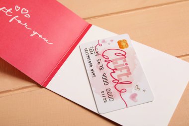 Renkli ahşap zemin üzerinde hediye kartı, yakın plan