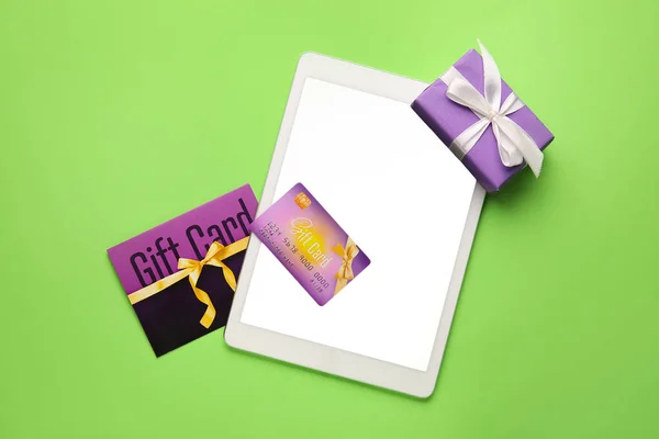 Geschenkkarte Und Tablet Computer Auf Farbigem Hintergrund — Stockfoto