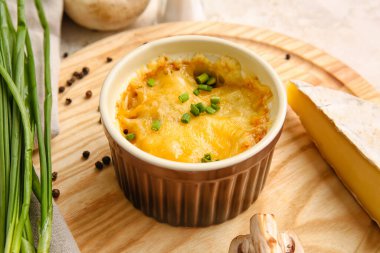 Ramekin with tasty julienne and ingredients on table, closeup