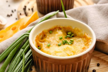 Ramekin with tasty julienne and ingredients on table, closeup