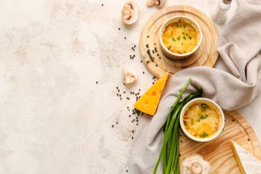 Ramekins with tasty julienne and ingredients on light background