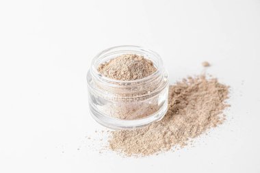 Jar with cosmetic clay on white background
