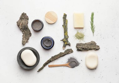Composition with cosmetic clay and soap on light background