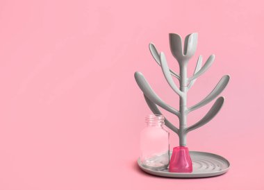 Drying rack for baby bottles on color background