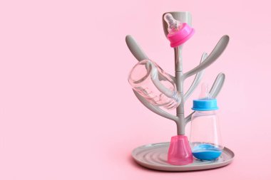Drying rack for baby bottles on color background