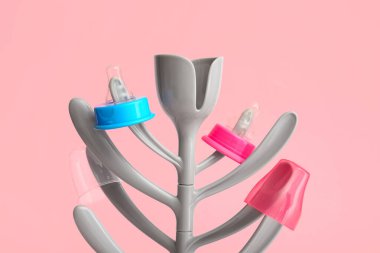 Drying rack for baby bottles on color background