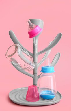 Drying rack for baby bottles on color background