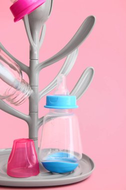 Drying rack for baby bottles on color background