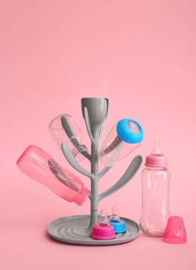 Drying rack for baby bottles on color background