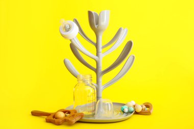 Drying rack for baby bottles on color background