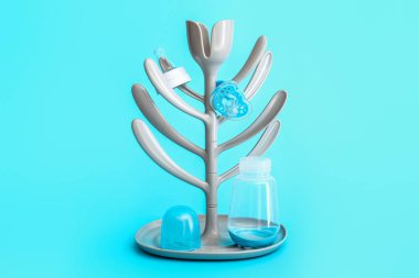 Drying rack for baby bottles on color background