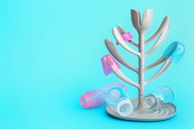 Drying rack for baby bottles on color background