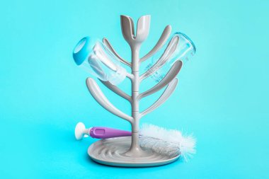 Drying rack for baby bottles on color background