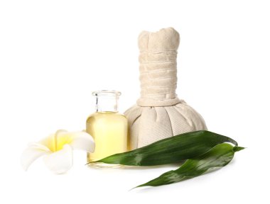 Composition with spa herbal bag, essential oil and floral decor on white background