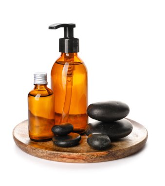 Bottles of cosmetic products and spa stones on white background