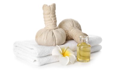 Clean towels, spa herbal bags and essential oil on white background