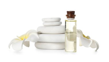 Composition with bottle of essential oil, spa stones and flowers on white background
