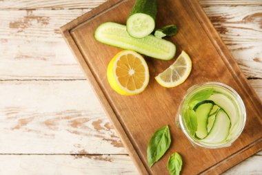 Glass with cucumber lemonade on wooden background