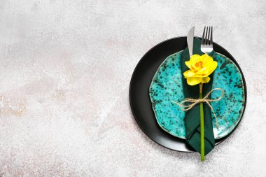 Beautiful table setting with narcissus flower on light background