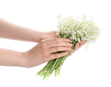 Female hands with beautiful lily-of-the-valley flowers on white background