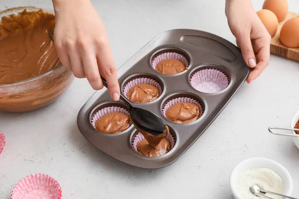 Woman cooking cupcakes in kitchen