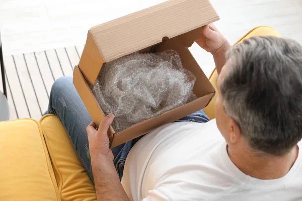 Senior Man Unpacking Box Home — Fotografia de Stock