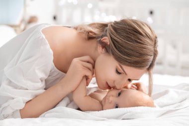 Mutlu anne ve tatlı bebek evde yatakta