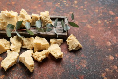 Arkaplanda kakao yağı ve okaliptüs dalı olan tahta, yakın plan.