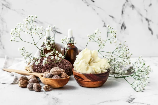 Composición Con Manteca Karité Frutos Secos Aceite Esencial Sobre Fondo — Foto de Stock