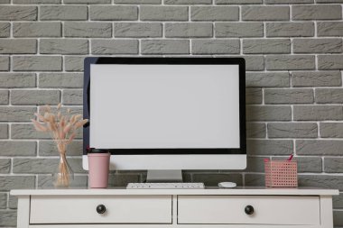 Modern bilgisayar tuğla duvarın yanındaki masada.