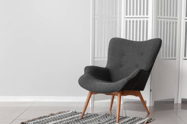 Modern koltuk ve katlanan ekran ışık duvarının yanında