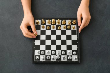 Koyu arkaplanda satranç oynayan kadın