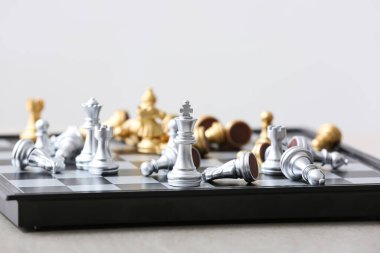 Hafif arkaplanda satranç taşları olan oyun tahtası