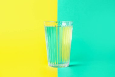 Renkli arkaplanda bir bardak su