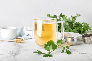 Bir fincan sıcak çay, maydanoz ve bal.