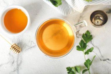 Bir fincan sıcak çay, maydanoz ve bal.