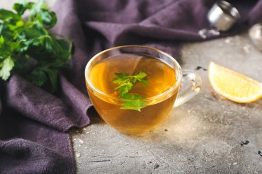 Bir fincan maydanozlu ve limonlu sıcak çay.