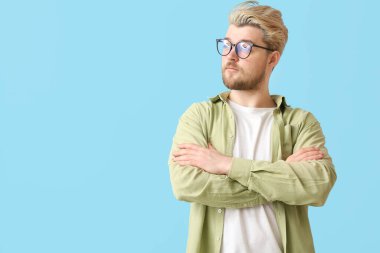 Renkli arka planda gözlük takan genç adam