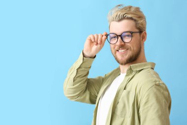 Renkli arka planda gözlük takan genç adam